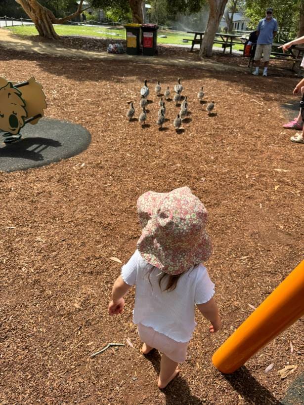 Criança de chapéu caminhando no playground ao ar livre